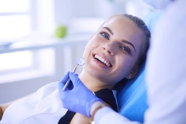 在牙科诊所检查牙齿的年轻女性病人，面带笑容. — 图库照片