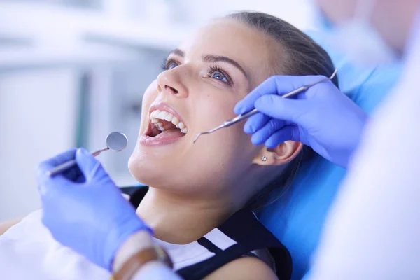 Mujer joven con la boca abierta examinando la inspección dental en el consultorio del dentista. — Foto de Stock