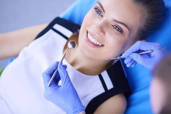 Joven paciente femenina con sonrisa bonita examinando la inspección dental en el consultorio del dentista. — Foto de Stock