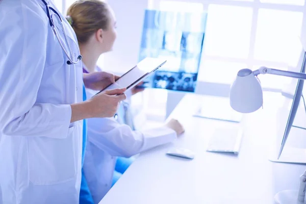 Közelkép lövés orvos tabletta és kolléga röntgen a háttérben. — Stock Fotó