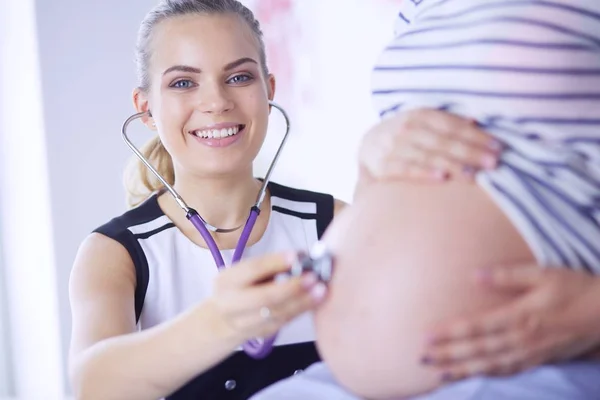 Portret młodej lekarki badającej kobietę w ciąży w klinice. — Zdjęcie stockowe