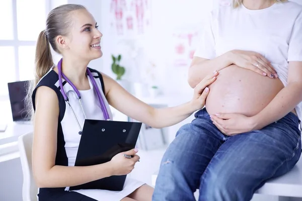 Young female doctor examining pregnant woman at the clinic. — Stock Photo, Image