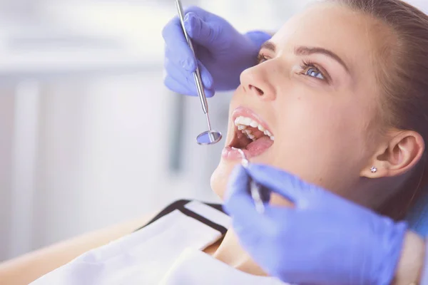 Mujer joven con la boca abierta examinando la inspección dental en el consultorio del dentista. — Foto de Stock