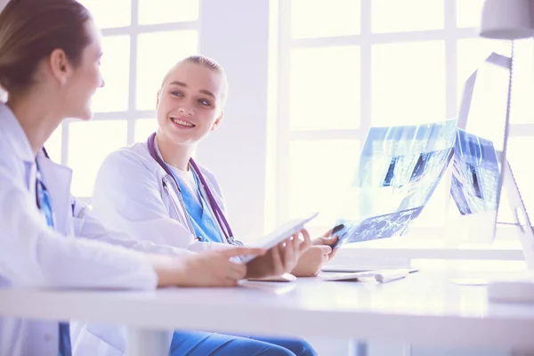 Female doctors looking and discussing x-ray image at hospital. — Stock Photo, Image