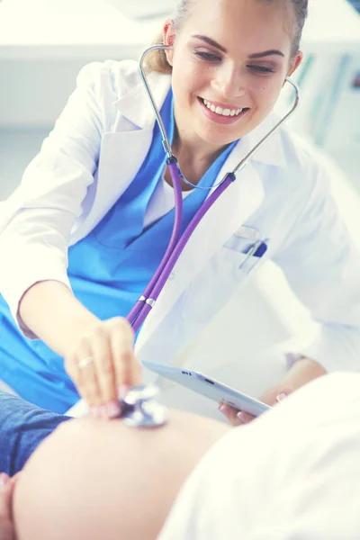 Jonge vrouwelijke arts onderzoekt zwangere vrouw in de kliniek. — Stockfoto