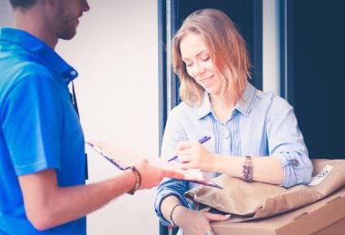 Mavi üniformalı gülümseyen kurye servis konseptine paket kutusu teslim eden teslimatçı. Mavi üniformalı gülümseyen teslimatçı.