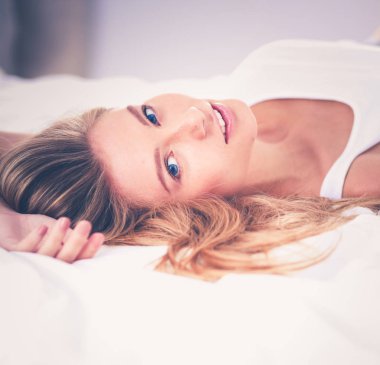 Güzel kadın evde yatağında yatarken. Güzel kadın