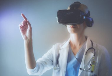 Sanal gerçeklik gözlüğü takan kadın doktor beyaz arka planda izole edilmiş..