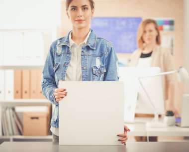 Masanın yanında duran iki genç kadın enstrüman, plan ve dizüstü bilgisayarla.