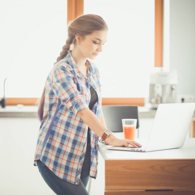 Güzel, genç, gülümseyen bayan doktor masada oturuyor ve yazıyor..