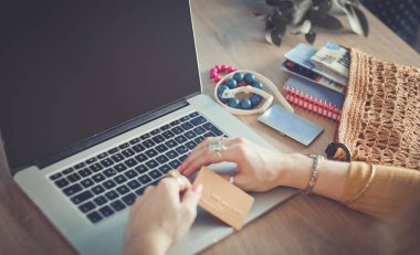 Genç bir kadın kahve molasında ya da kahve molasında dizüstü bilgisayar kullanıyor..