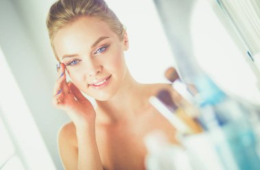 Genç güzel kadın ayna, Masa başında oturan yakınındaki makyaj yapma