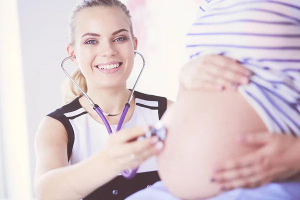 Retrato de Jovem médica examinando mulher grávida na clínica . — Fotografia de Stock