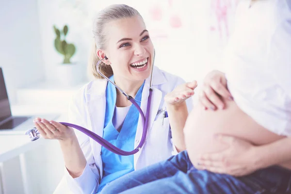 Jovem médica com estetoscópio falando com mulher grávida no hospital. — Fotografia de Stock