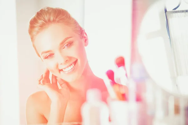 Fiatal gyönyörű nő, ami a make-up tükör, a pultnál ülő közelében — Stock Fotó