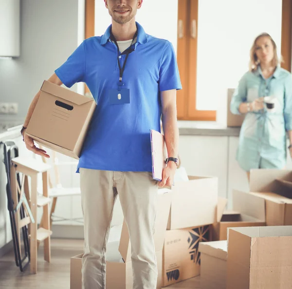 Smiling delivery man in blue uniform delivering parcel box to recipient - courier service concept. Smiling delivery man in blue uniform — Stock Photo, Image