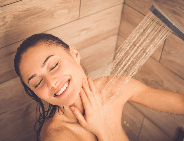 Genç beautyful kadın banyoda duş altında.