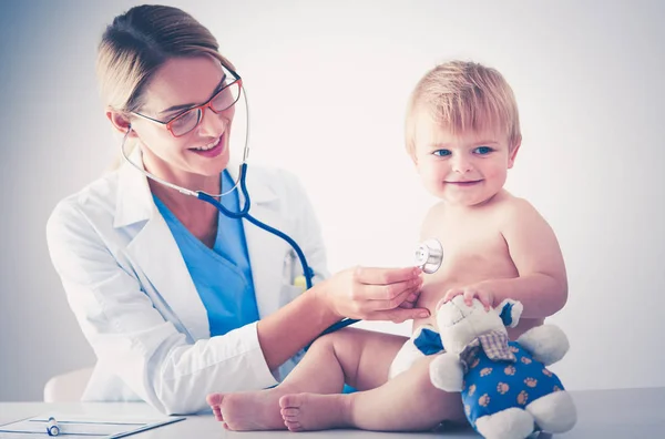 Vrouwelijke arts luistert kind met een stethoscoop in de kliniek — Stockfoto