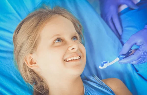 Niña sentada en el consultorio de dentistas. — Foto de Stock