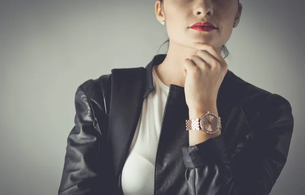 Portrait of beautiful young brunette woman in stylish black jacket on gray. — Stock Photo, Image