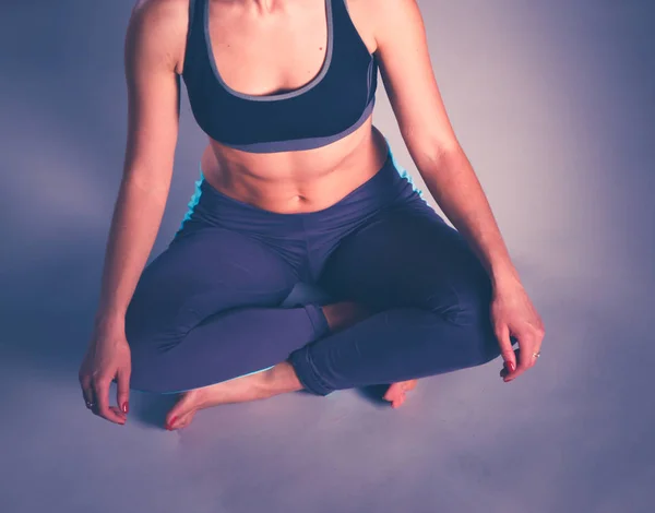 Mujer joven sentada en el suelo en posición de loto. yoga — Foto de Stock