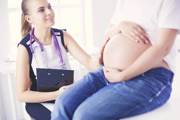 Giovane medico donna esaminando donna incinta presso la clinica. — Foto Stock