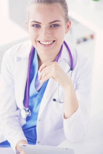 Portret van een vriendelijke vrouwelijke arts met stethoscoop en tablet in handen. — Stockfoto