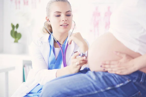 Fiatal nő orvos sztetoszkóppal beszél terhes nővel a kórházban. — Stock Fotó