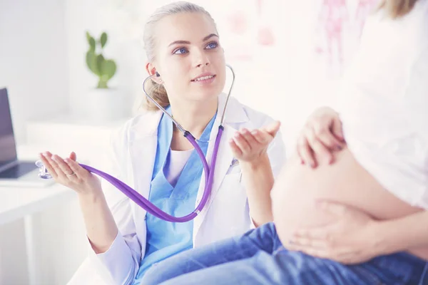 Mladá žena lékař se stetoskopem mluvit s těhotnou ženou v nemocnici. — Stock fotografie