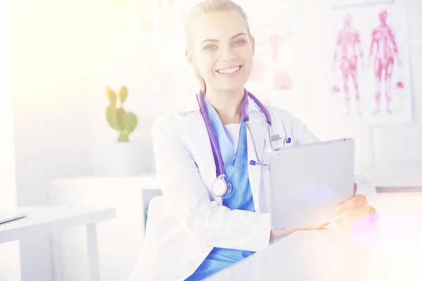 Retrato de médico fêmea amigável com estetoscópio e tablet nas mãos. — Fotografia de Stock