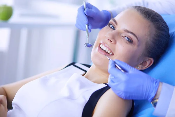 Mujer joven con la boca abierta examinando la inspección dental en el consultorio del dentista. —  Fotos de Stock