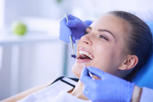 Mujer joven con la boca abierta examinando la inspección dental en el consultorio del dentista. — Foto de Stock