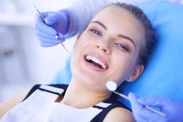 Mujer joven con la boca abierta examinando la inspección dental en el consultorio del dentista. — Foto de Stock