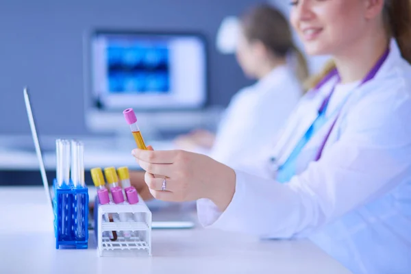 Assistente de laboratório colocando tubos de ensaio no suporte, Visão de close-up focada nos tubos com testes . — Fotografia de Stock