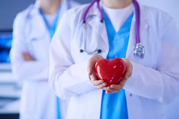 Pouls recadré de deux jeunes médecins femelle avec stéthoscope tenant le cœur. — Photo