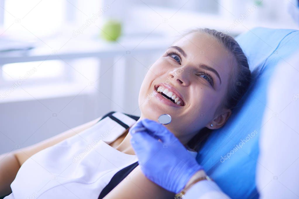 Young Female patient with pretty smile examining dental inspection at dentist office