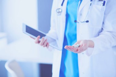 Doktorların ellerinde haplar ve bir bardak su tutarken yakın plan çekimleri..