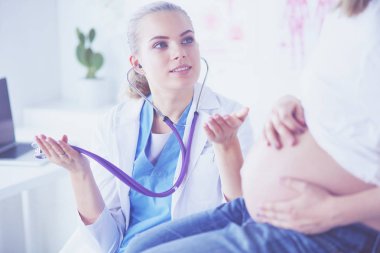 Steteskoplu genç bayan doktor hastanede hamile bir kadınla konuşuyor..