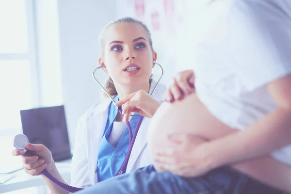 Jonge vrouwelijke arts onderzoekt zwangere vrouw in de kliniek. — Stockfoto