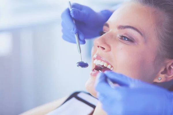 Ung kvinnelig pasient med åpen munn som undersøker tannlegeundersøkelsen. – stockfoto