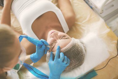 Kaşlar için kalıcı makyaj. Güzellik salonunda kalın kaşlı güzel bir kadın..