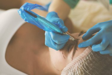 Kaşlar için kalıcı makyaj. Güzellik salonunda kalın kaşlı güzel bir kadın..