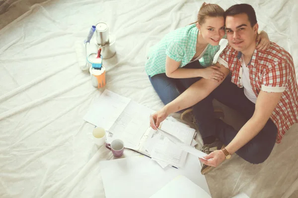 Casal jovem sentado no chão e calculando sobre eles economia. Casal jovem — Fotografia de Stock