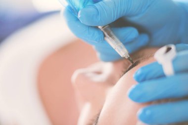 Kaşlar için kalıcı makyaj. Güzellik salonunda kalın kaşlı güzel bir kadın..