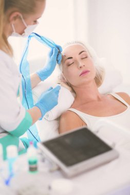 Kaşlar için kalıcı makyaj. Güzellik salonunda kalın kaşlı güzel bir kadın..