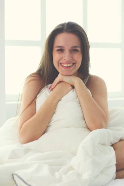 Güzel bir kadın yatağında uzanıyor..