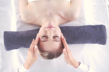 Masaj masasında uzanmış gözleri kapalı rahatlayan genç bir kadın. - Kadın. Spa salonu