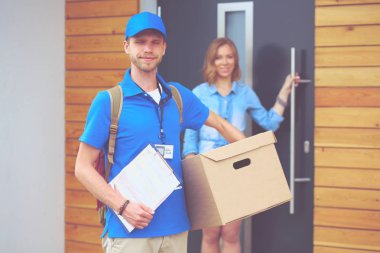 Mavi üniformalı gülümseyen kurye servis konseptine paket kutusu teslim eden teslimatçı. Mavi üniformalı gülümseyen teslimatçı.