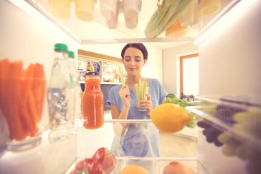 Taze meyve ve sebzelerle dolu açık bir buzdolabı. Buzdolabını aç