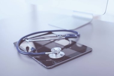 Tıbbi ekipman: Beyaz arka planda mavi steteskop ve tablet. Tıbbi ekipman